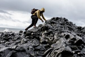 Challenges & Knowledge | A Man Climbing In A Stony Mountain Near The Sea