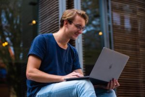 Man smiling at screen because bing is so easy to use. 