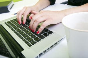 Woman typing copy on laptop for a good ad 