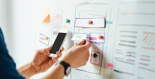 woman holding phone while making a physical story board for a website