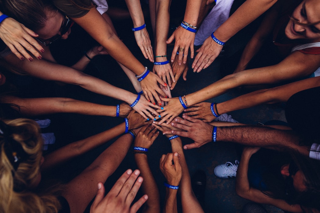 a group of people putting their hands in together