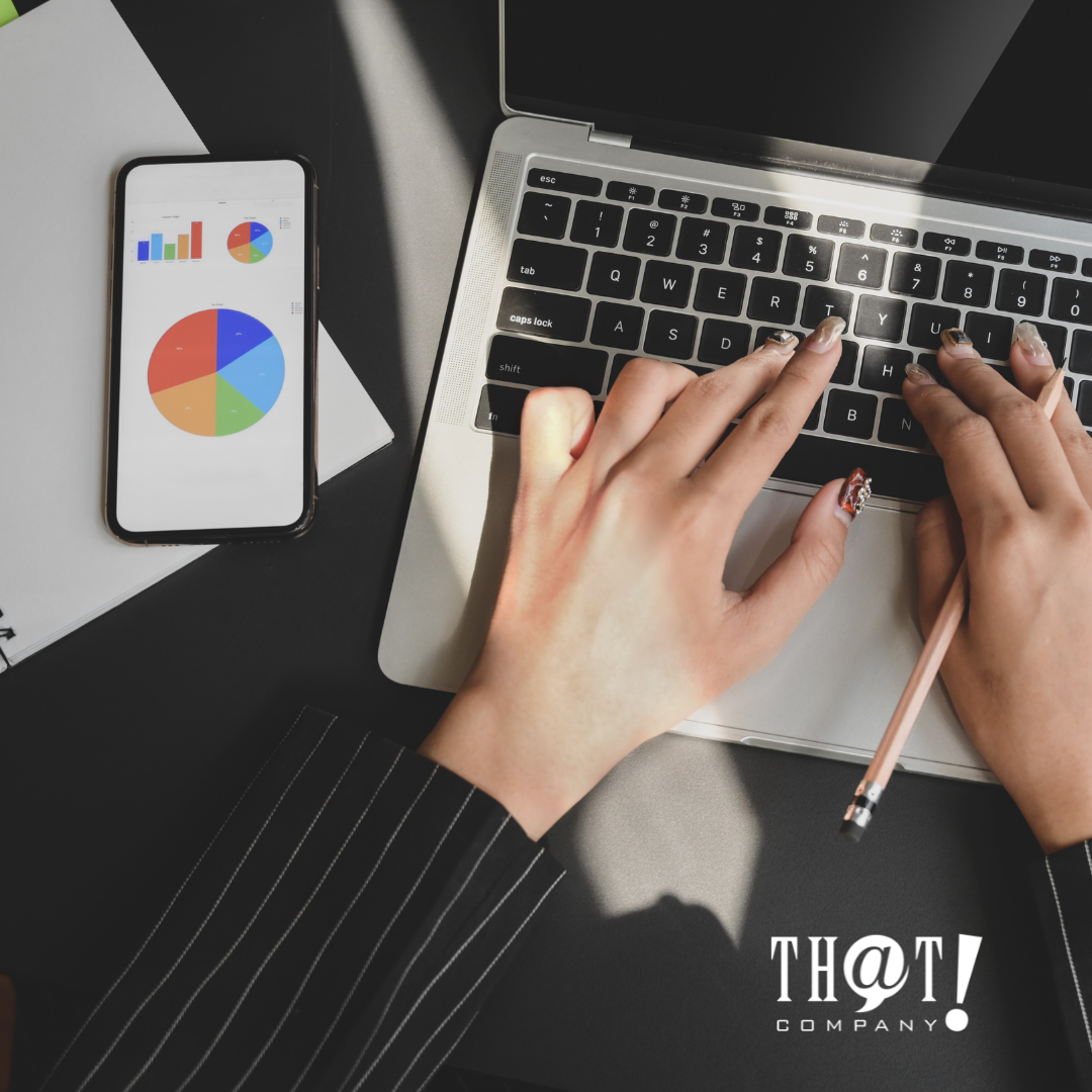 The Pros Of UGC | Hands Typing in Laptop While Holding a Pencil With Phone on the Side Showing Graphs