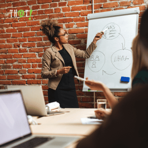 Bid Strategy | A Woman Writing On A White Board And Leading A Meeting